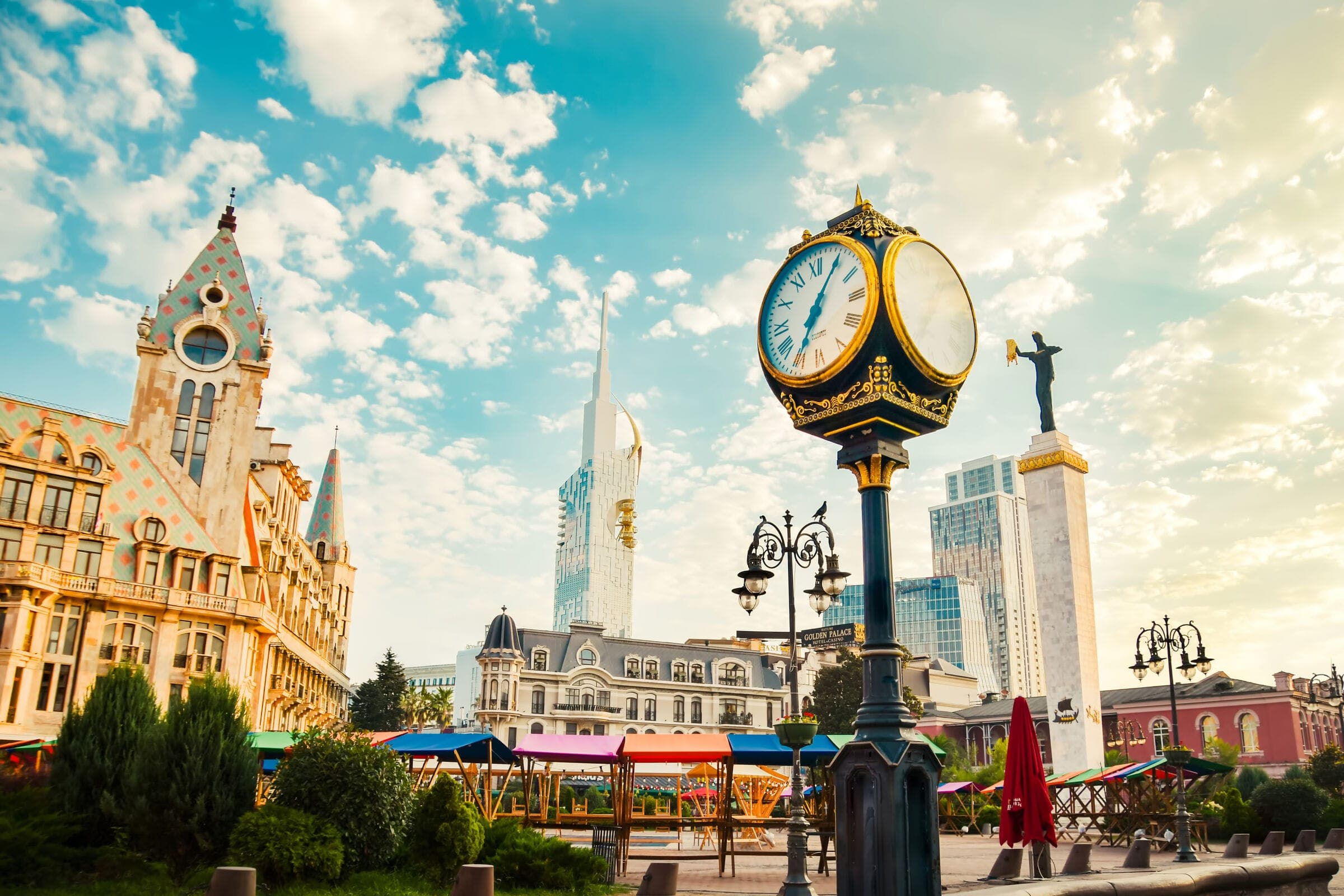 A city square with a clock and towers