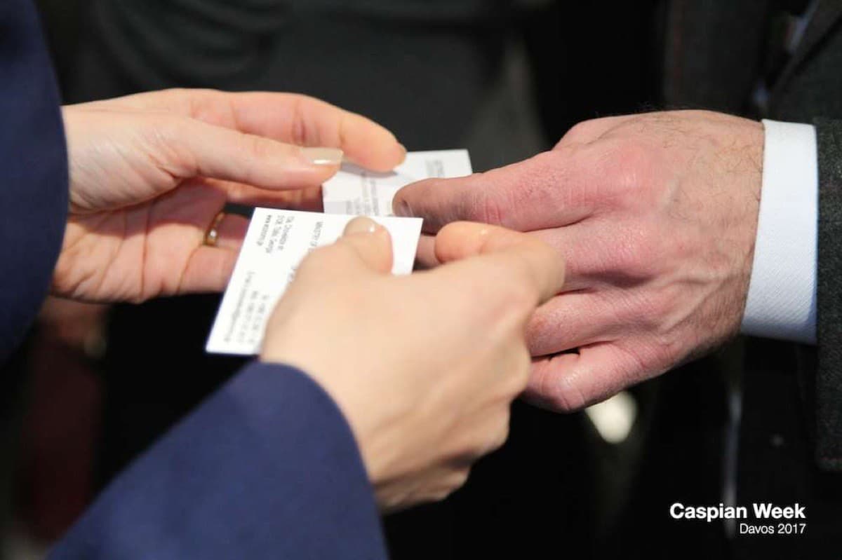 Two guests exchanging business cards at Caspian Week in Davos, 2017