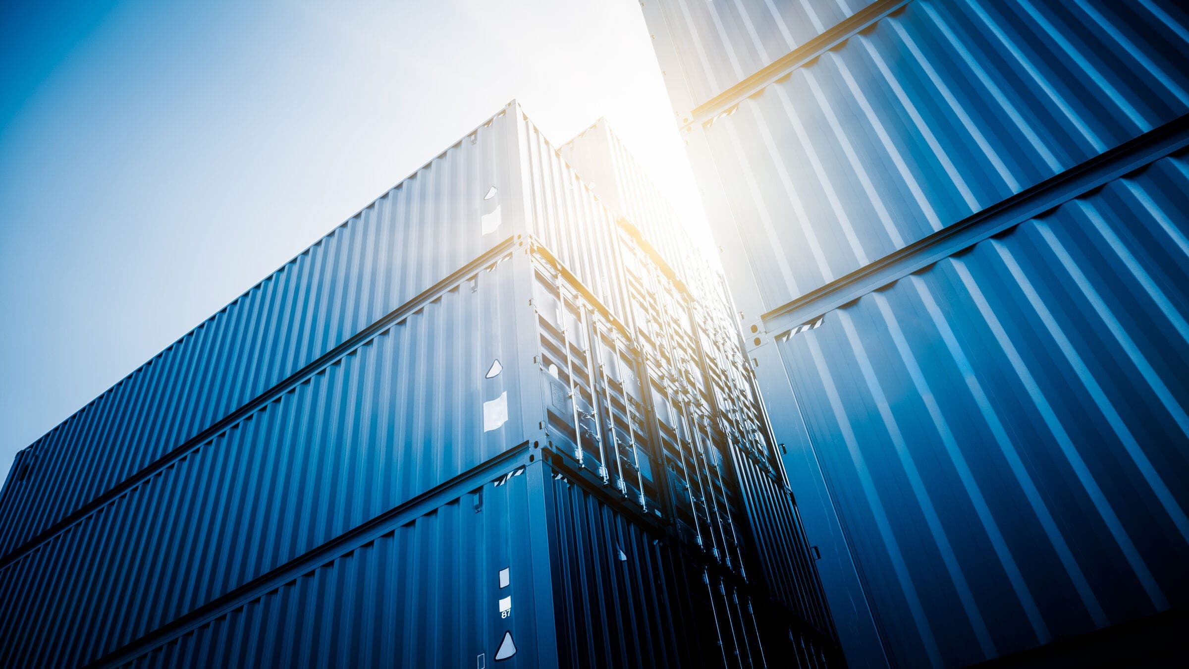 Stacked shipping containers in blue light